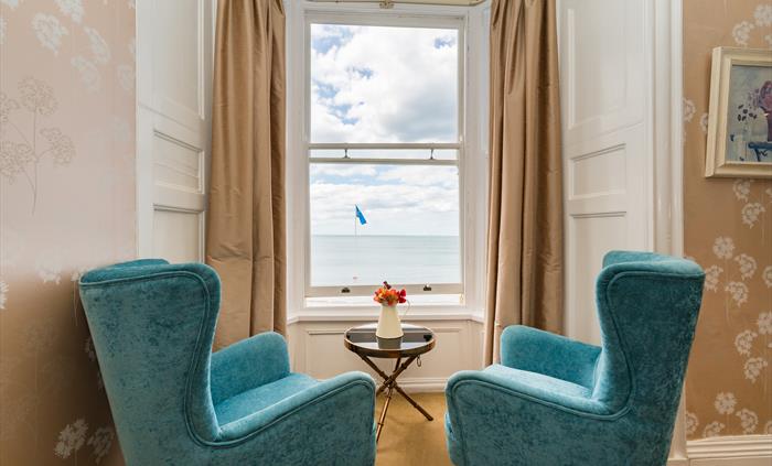Hotel room with two chairs and table by the window with a sea view